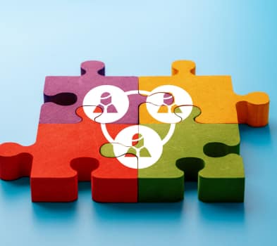 Experienced Matchmakers Four interlocking puzzle pieces in red, purple, yellow, and green, overlaid with connected person icons on a blue background.